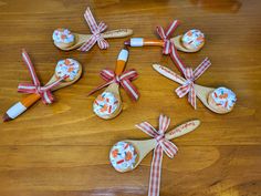 wooden spoons decorated with flowers and bows on top of a wood table in the shape of crosses