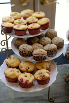 three tiered trays filled with cupcakes and muffins on top of each other