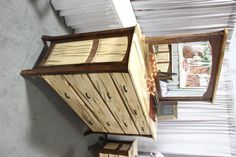 a wooden dresser sitting next to a white table with a mirror on top of it