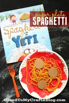 a paper plate with spaghetti on it next to a book