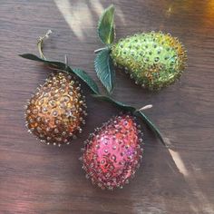 three strawberries on a table with leaves and other things to decorate the top one