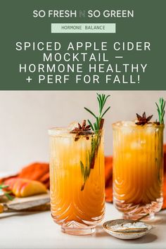 two glasses filled with apple cider and rosemary garnish on top of a table