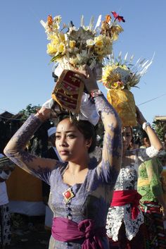 a woman holding flowers in her hands and other people around her with tattoos on their arms