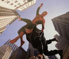 two men are jumping in the air on their skateboards with skyscrapers behind them