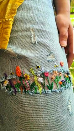 someone is showing off their jeans with flowers on them