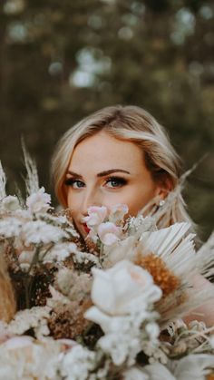 a woman holding a bouquet of flowers in front of her face