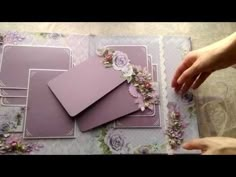 a table topped with lots of cards covered in purple and pink flowers on top of it