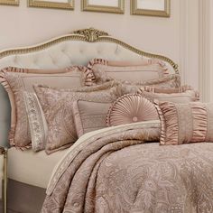 a bed with pink comforters and pillows in a room