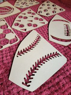 paper cutout shapes with footballs and other sports related items on a pink blanket