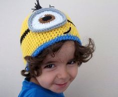 a young child wearing a crocheted hat with an eyeball