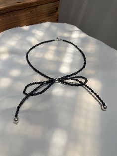 a black beaded necklace on a white table