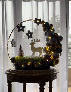 a christmas wreath with lights and ornaments on it in front of a window sill