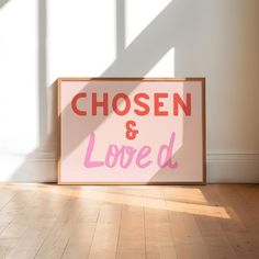 a wooden sign that says chosen and loved on it in front of a white wall