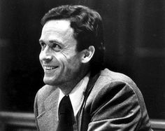 a black and white photo of a man sitting at a table with papers in front of him