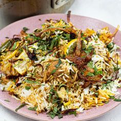 a pink plate topped with rice and vegetables