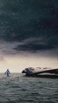 a space shuttle floating on top of the ocean next to a man in an astronaut suit