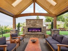 an outdoor living area with couches and a fireplace