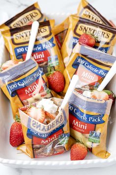 several bags of frozen food on a white tray with strawberries and yogurt