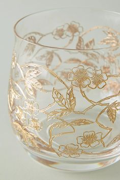 a clear glass with gold floral designs on it