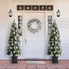 two christmas trees and a wreath on the front door