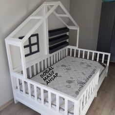 a white dollhouse bed with a mattress in it