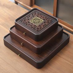 two wooden boxes sitting on top of a table next to each other with designs on them