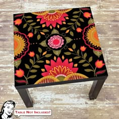 a black and red flowered stool on wooden floor with wood planks in the background