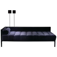 a black couch with two lamps on top of it