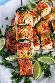 grilled salmon and vegetables on skewers with lime wedges