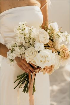 a woman holding a bouquet of white flowers