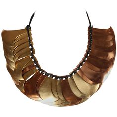 Sculptural brass and gilt metal pieces make up this dramatic collar from Yves Saint Laurent as seen on the spring 1983 runway. This is a very rare and unique piece. Beautiful patina to metal. Strung on cord with beads at ends. Approximate measurements: each piece is approximately 2.5" by 2.5" and end to end 34". Numbered 070/600. Condition is very good. Copper Necklace 1stdibs, Dramatic Collar, Kendall Jenner Chanel, Runway Necklace, Kardashian Kollection, Number Necklace, Tooth Necklace, Brass And Copper, Resin Ideas