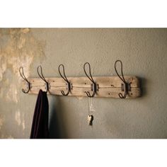 a coat rack made out of wood and metal hooks