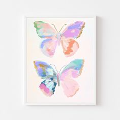 a painting of three butterflies on a white wall with pink, blue and green colors