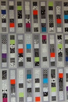 a quilted wall hanging with different colored squares on it