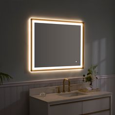 a bathroom sink with a lighted mirror above it