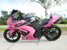 a pink and black motorcycle parked on the street