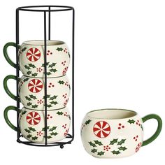 three mugs with holly and pepperminks on them are sitting next to each other