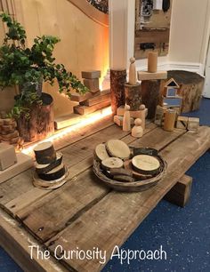 a wooden table topped with plates and vases on top of blue carpeted flooring