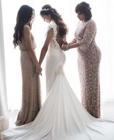 three women standing in front of a window with their hands on each other's hips