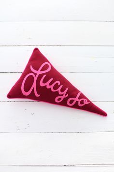 a red triangle shaped pillow with the word yaygo on it's side