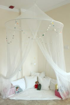 a canopy bed with white netting and pillows