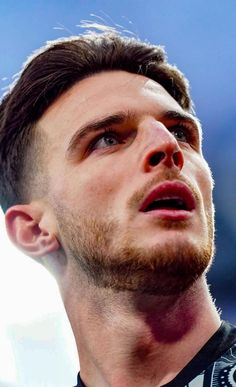 a close up of a person wearing a black shirt and looking off to the side