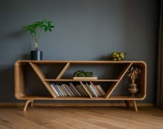 a wooden shelf with books on top of it and a potted plant next to it