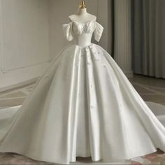 a white wedding dress on display in a room