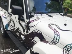 a white jeep with an octopus painted on it's front door and side window