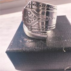 a silver ring sitting on top of a black box