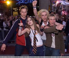 a group of young people standing next to each other in front of a crowd at night