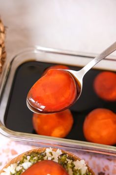 a spoon with some food in it on top of a table next to a container