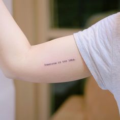 a woman's arm with the words tomorrow is too late tattooed on her left arm