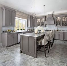 a large kitchen with gray cabinets and marble flooring